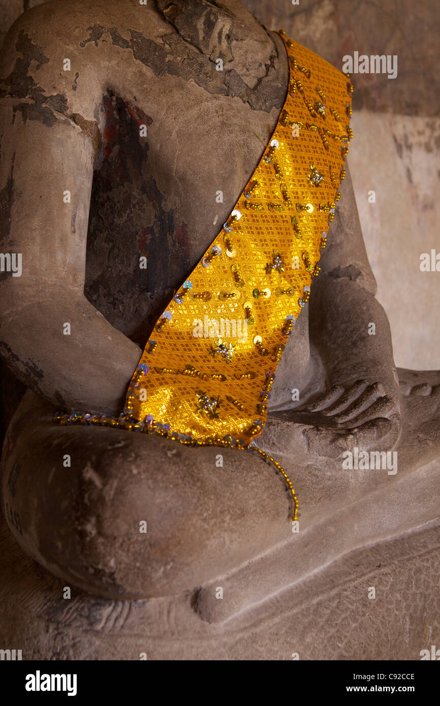 Ein beschädigte Sitzender Buddha trägt eine gestickte Safran Schärpe innerhalb eines inneren Galerien eine Tempelanlage Angkor Wat Stockfoto