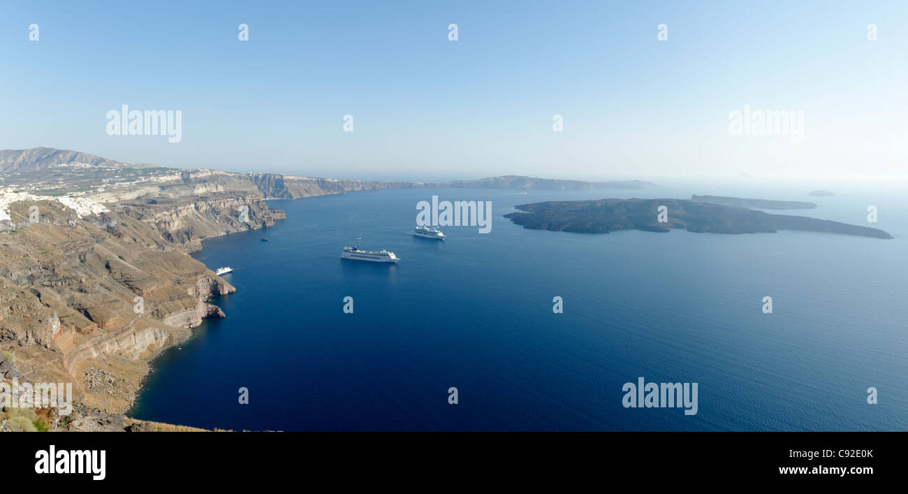 Panoramablick über die weiten Santorini Caldera mit Kreuzfahrtschiffen in seinem blauen Meer. Auf der linken Seite ist die weiß getünchten Hauptstadt Fira. Stockfoto