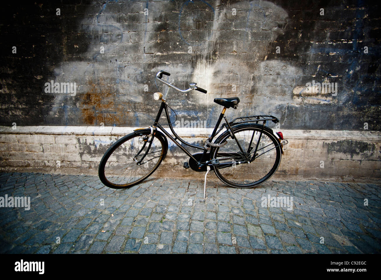Oldtimer Fahrrad geparkt auf gepflasterten Straße Stockfoto