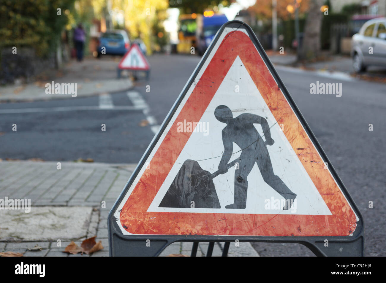 Männer in Arbeit Straßenschild platziert auf einer Straße in Nord-London, England Stockfoto