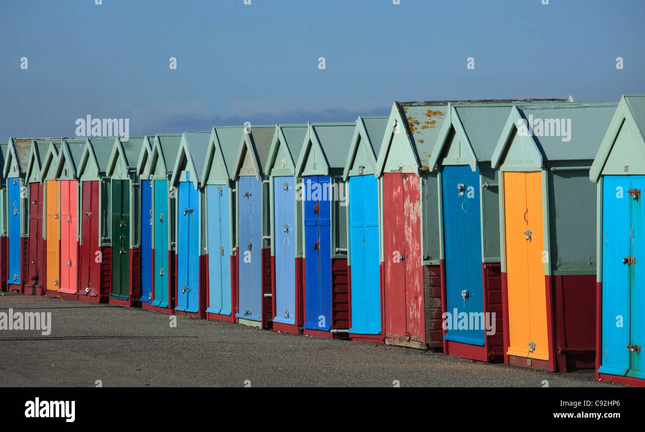 Brighton hat Reihen von bunten Strandhütten an der Strandpromenade. Die Türen sind helle Farben lackiert. Stockfoto