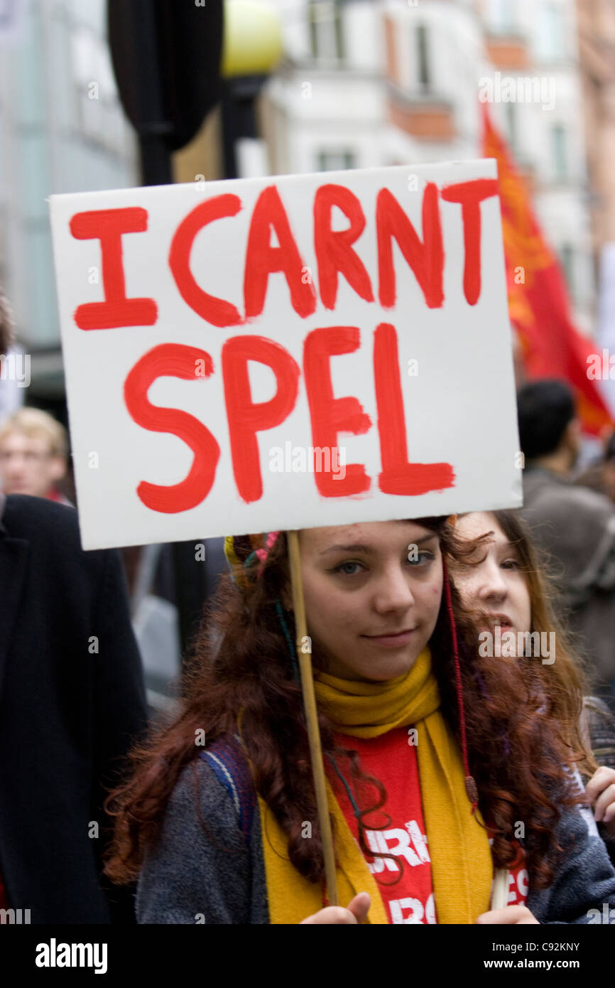 Eine Demonstratorin hält ein falsch geschriebenes Plakat mit der Aufschrift "I carnt Spel" – ein absichtlicher Fehler für "Ich kann nicht buchstabieren" – während eines Studentenprotests in Zentral-London, Großbritannien, gegen Kürzungen der öffentlichen Ausgaben und steigende Studiengebühren, wobei sie mit Satire die Befürchtungen hervorhebt, dass eine reduzierte Finanzierung zu sinkenden Bildungsstandards führen könnte Stockfoto