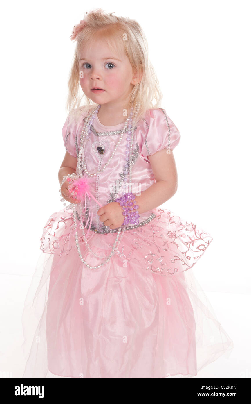 kleines Mädchen in rosa Fee Kleid vorläufig Blick in die Kamera vor weißem Hintergrund Stockfoto