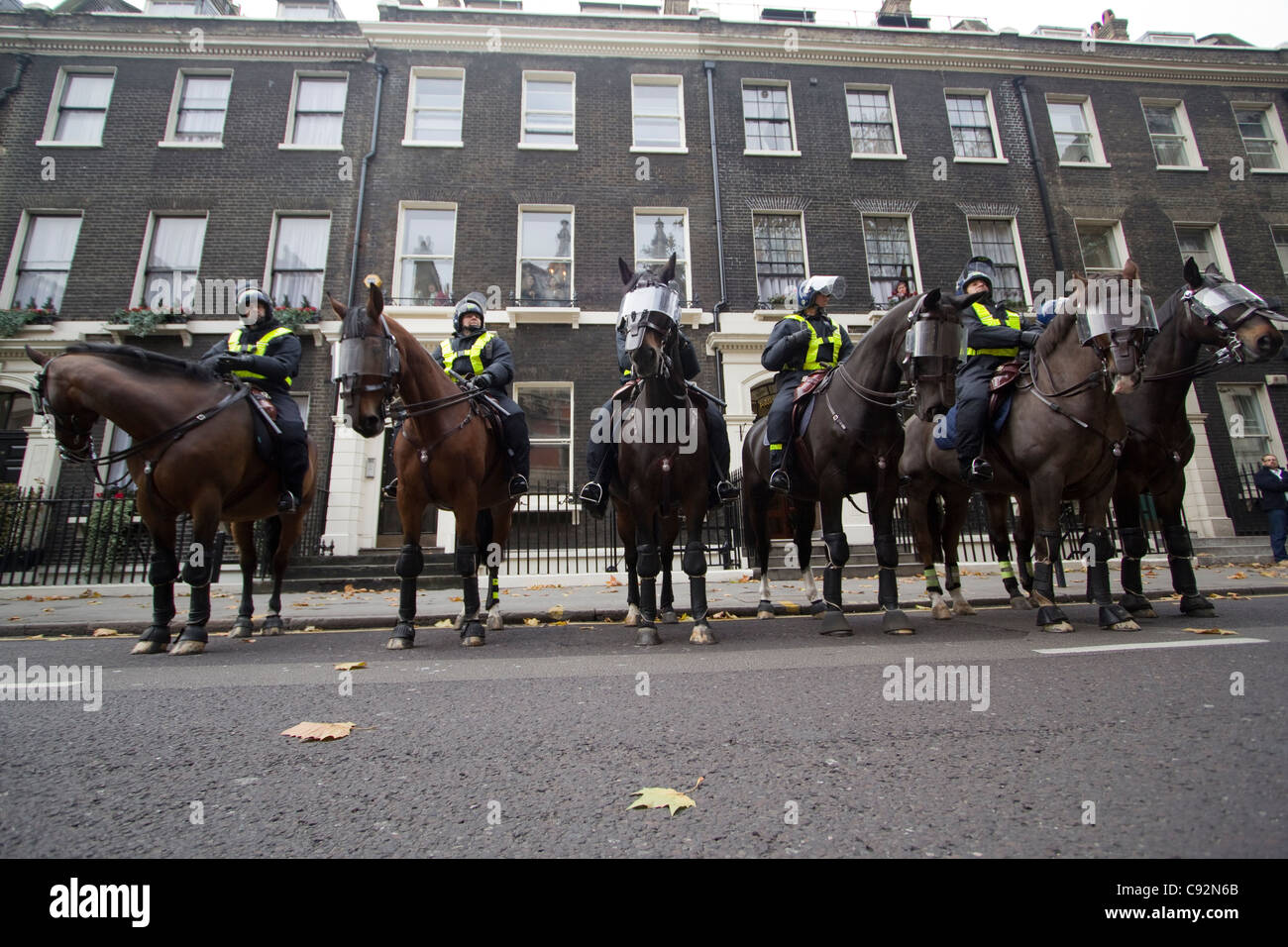 Die Polizei, die gepanzerte Reitpferde trägt, steht während eines Studentenprotests im Zentrum von London, Großbritannien, an, während Demonstranten gegen Kürzungen der öffentlichen Ausgaben und höhere Studiengebühren sprechen Stockfoto