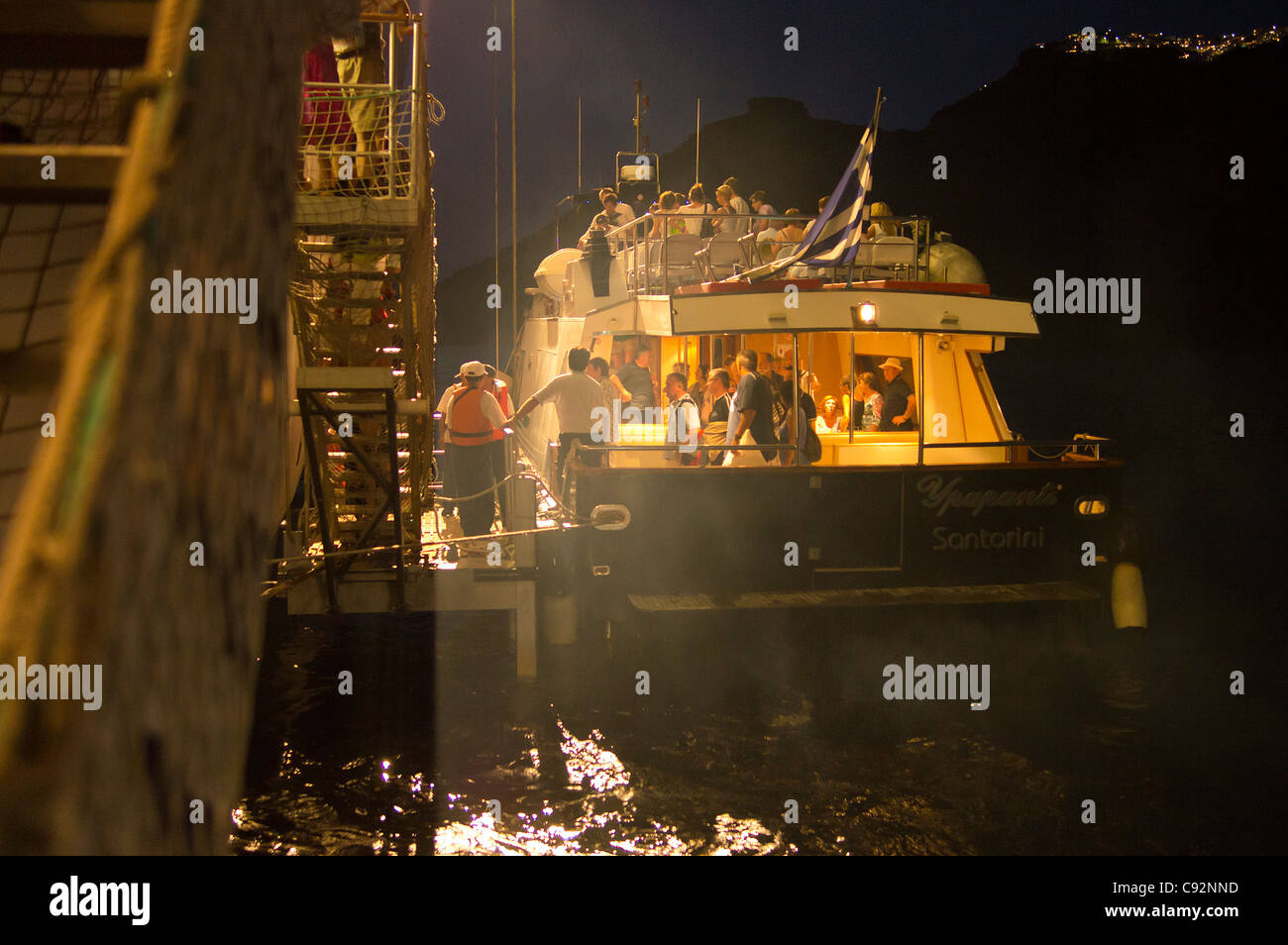Santorini - ein Shuttleboot Touristen kehrt das Kreuzfahrtschiff MSC Armonia, nach Einbruch der Dunkelheit - wieder einschiffen. Stockfoto