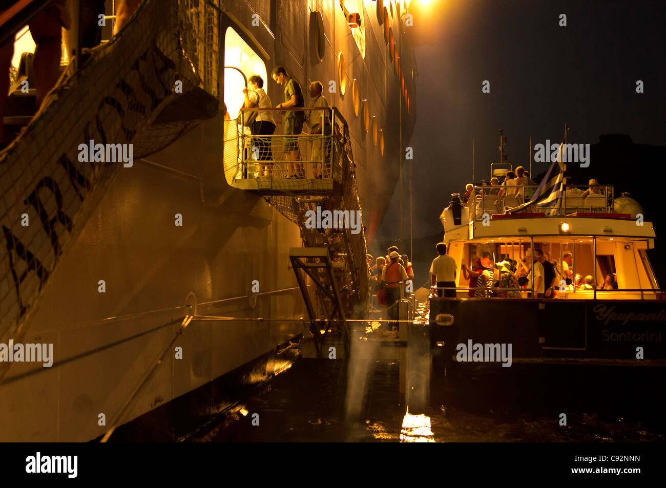 Santorini - ein Shuttleboot Touristen kehrt das Kreuzfahrtschiff MSC Armonia, nach Einbruch der Dunkelheit - wieder einschiffen. Stockfoto