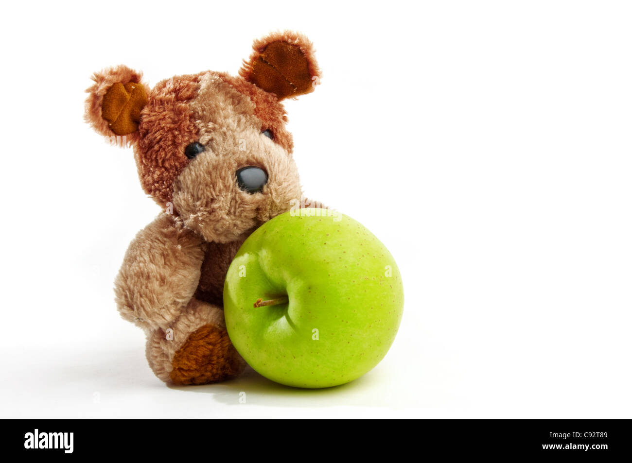 Netter kleiner Teddy Bär hält einen Apfel über einen weißen Hintergrund  Stockfotografie - Alamy