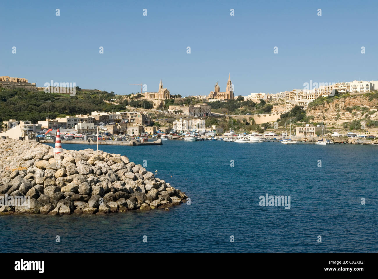 Die Einfahrt in den Hafen in Mgarr bietet Besuchern einen beeindruckenden Blick auf die Stadt und seine Hügel Kirche. Stockfoto