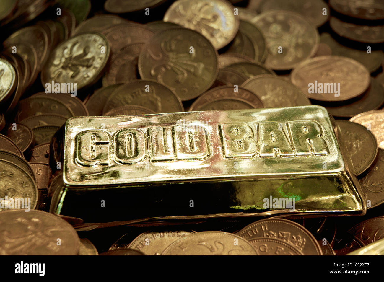 Britische Münzen und Nachahmung gold Bullion Bar in UK Seaside Resort Spielhalle Penny Falls Spielautomat Glücksspiel Stockfoto