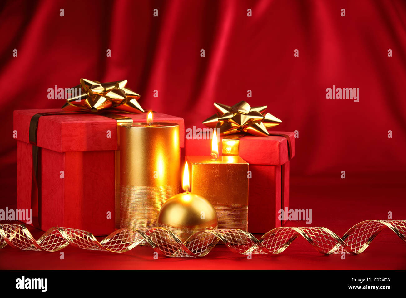 Weihnachts-Geschenk-Boxen, dekoriert mit Kerzen und Band Stockfoto