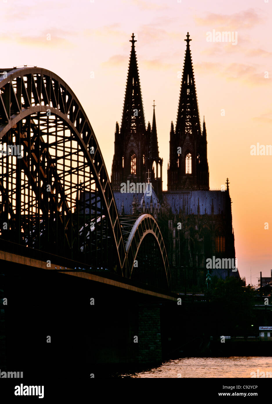 Köln Kölner Dom Silhouette gegen den Abendhimmel über der Hohenzollern-Eisenbahnbrücke über den Fluss Rhein, Deutschland Stockfoto