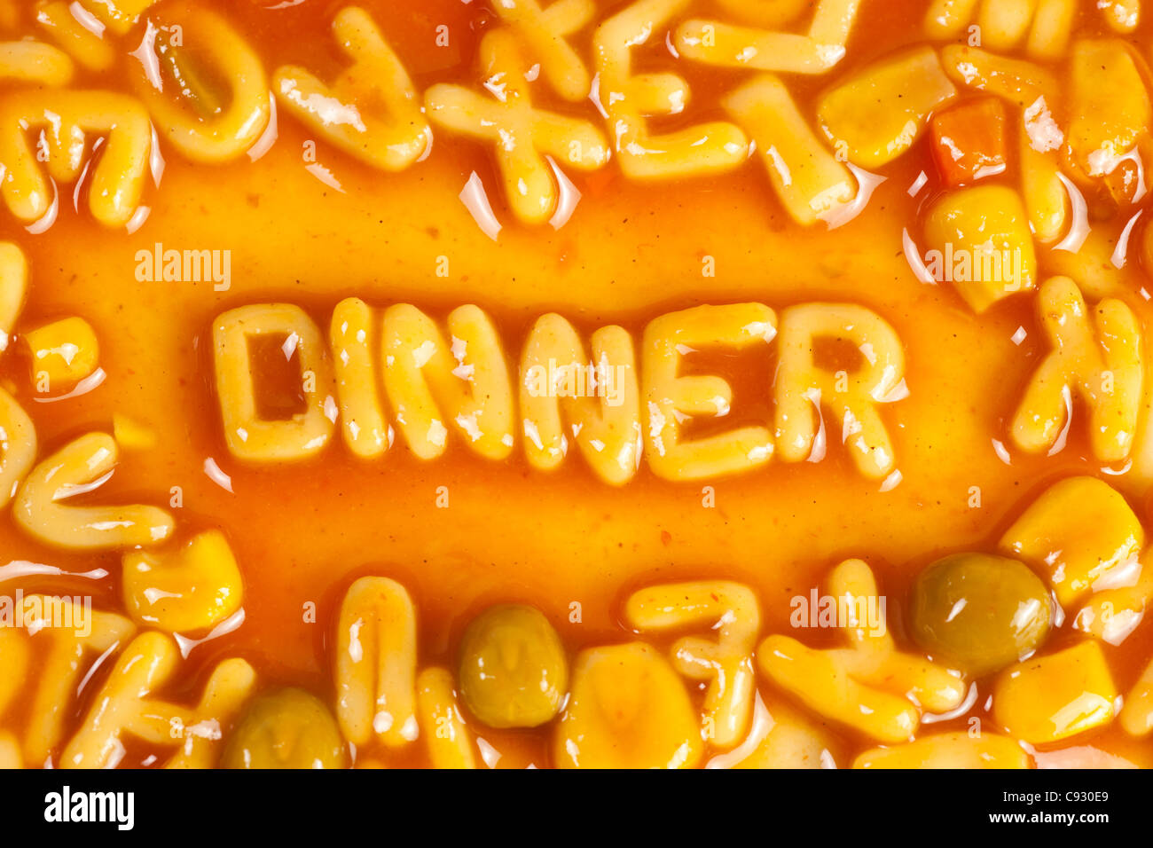 Alphabet geformten Nudeln bilden das Wort Abendessen in Tomatensauce Stockfoto