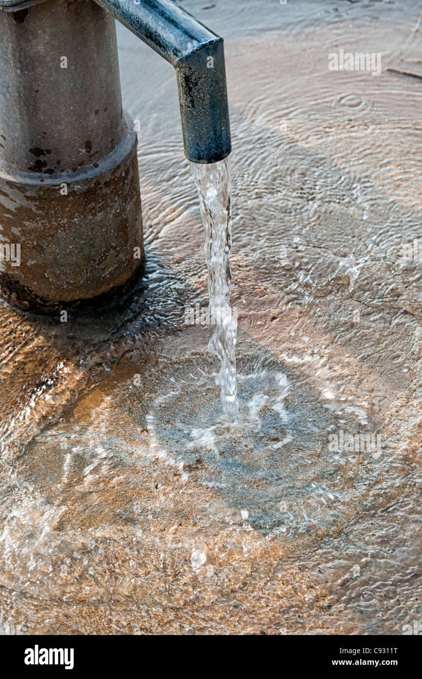 Wasser, das aus einer Wasserpumpe in der indischen Landschaft. Indien Stockfoto