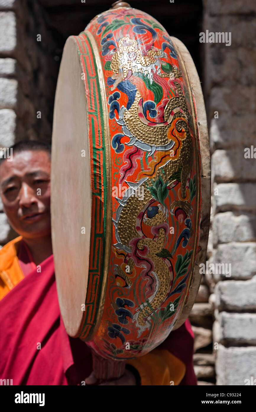 Ein buddhistischer Mönch im Tempel mit einer dekorierten zeremonielle Nga Kurjey Lhakhang Chen drum. Stockfoto