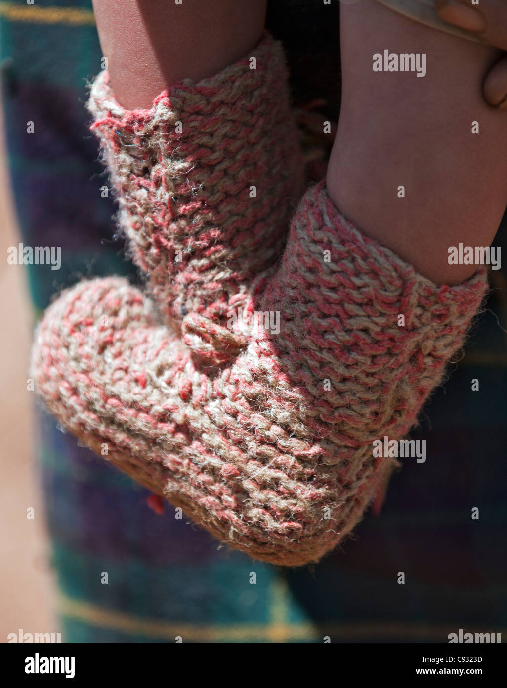 Ein Kind trägt Hand gestrickte wollene Booties im Chumey Valley. Stockfoto