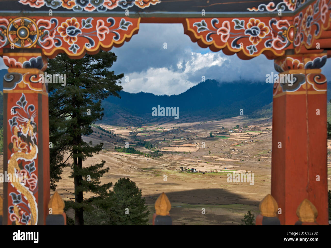 Ein Blick auf das fruchtbare Phobjikha Tal auf dem geschmückten Balkon des bhutanischen Haus umrahmt. Stockfoto