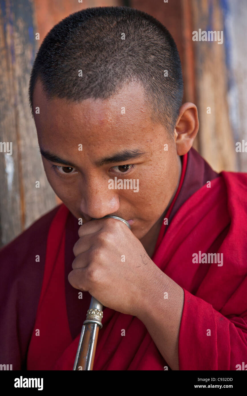 Ein Mönch, ein langes Horn bläst genannt Kot-Chen, in Wangdue Phodrang Dzong (Festung). Stockfoto