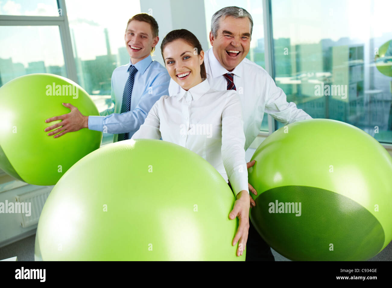 Porträt des freudigen Geschäftspartner mit großen Kugeln, Blick in die Kamera im Büro Stockfoto