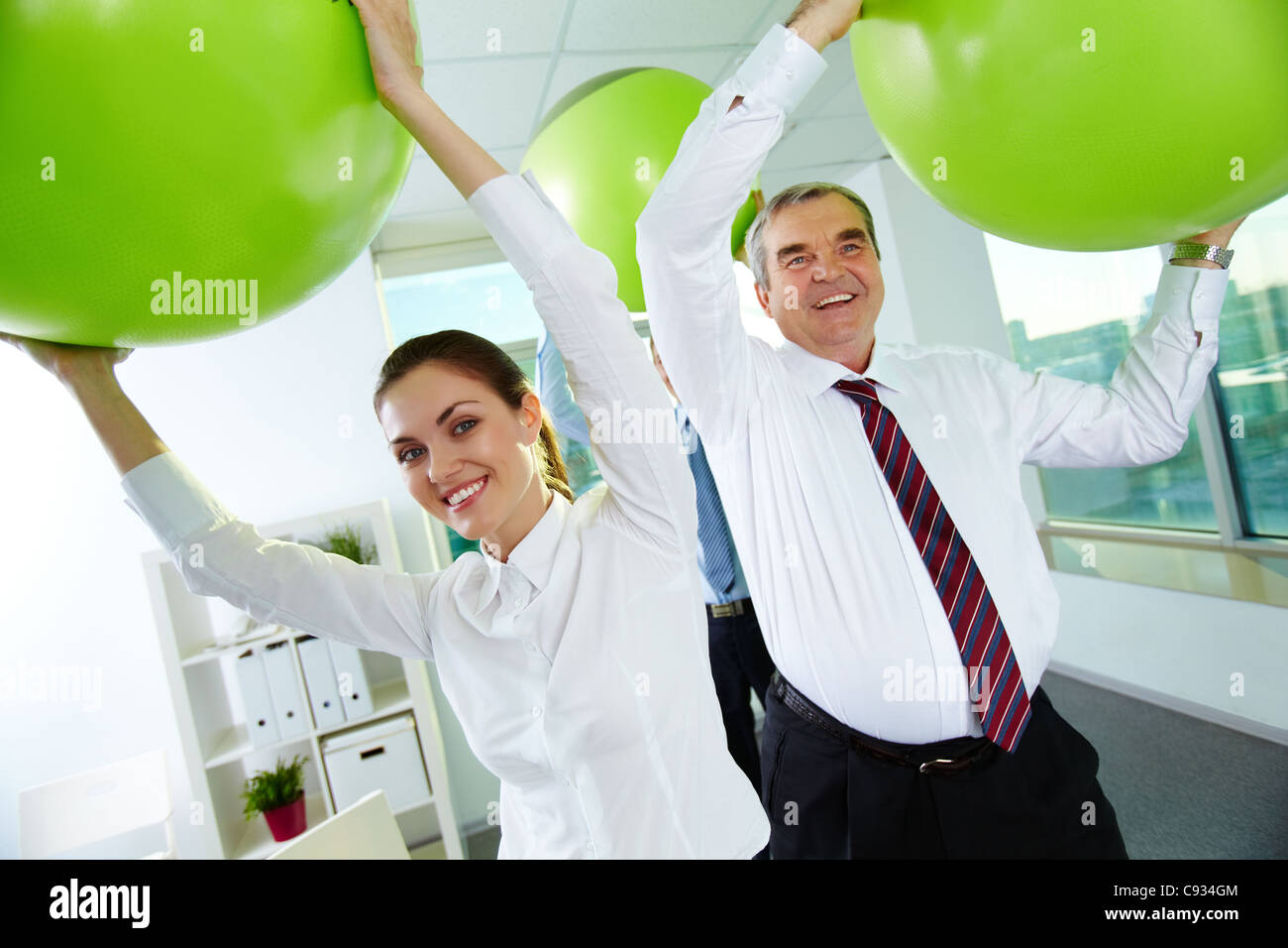 Porträt des freudigen Geschäftspartner mit großen Bällen im Büro spielen Stockfoto