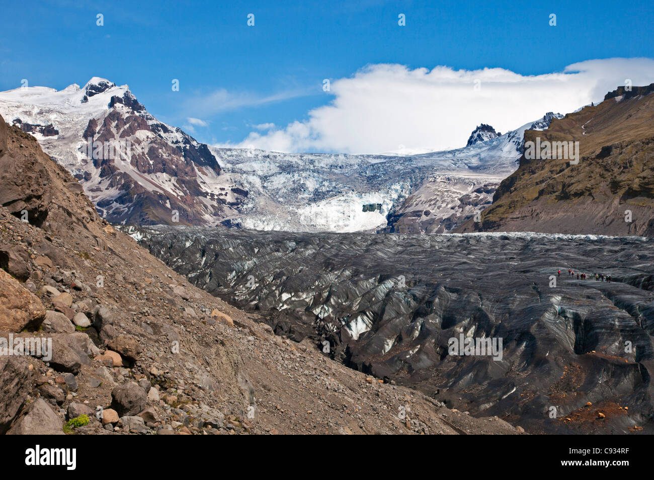 Besucher, die Svinsfaellsjokull Gletscher mit Steigeisen angeschnallt zu ihren Stiefeln. Stockfoto