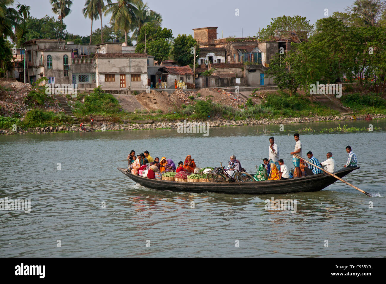 Eine überfüllte Fähre überquert Hooghly River nach Kalna mit Körben von landwirtschaftlichen Produkten auf dem Markt zu verkaufen. Stockfoto