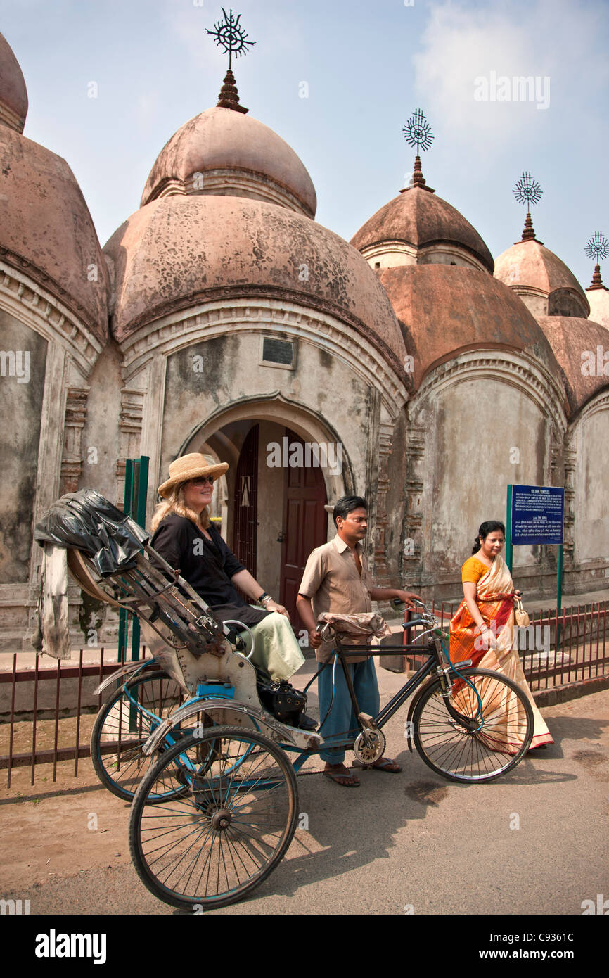 Ein Tourist in einer Fahrrad-Rikscha außerhalb der 108 Ziegel Shiva Tempel von Kalna. Stockfoto