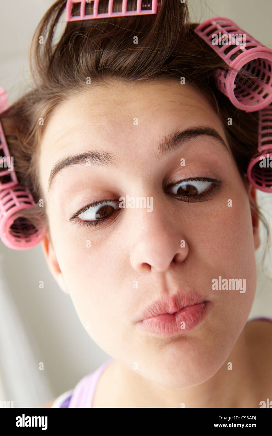 Teenager-Mädchen mit Haar in Lockenwicklern zieht ein Gesicht Stockfoto