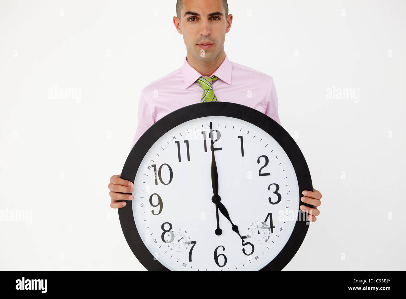 Junger Geschäftsmann mit riesigen Uhr Stockfoto