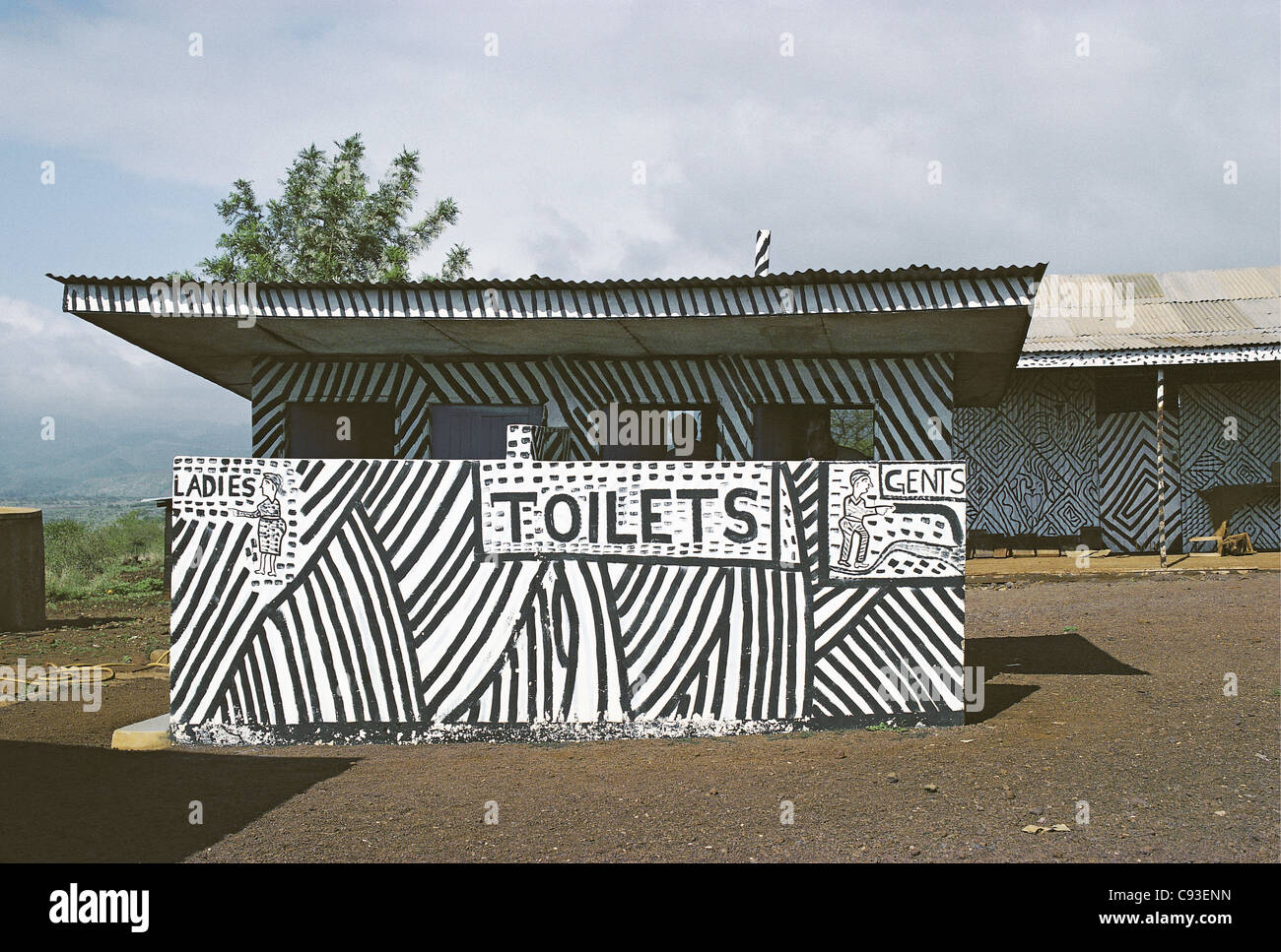 Toiletten dekoriert mit Zebra schwarzen und weiße Streifen mit Herren männlich und weibliche Eingängen Damen in der Nähe von Lake Manyara Tansania Stockfoto