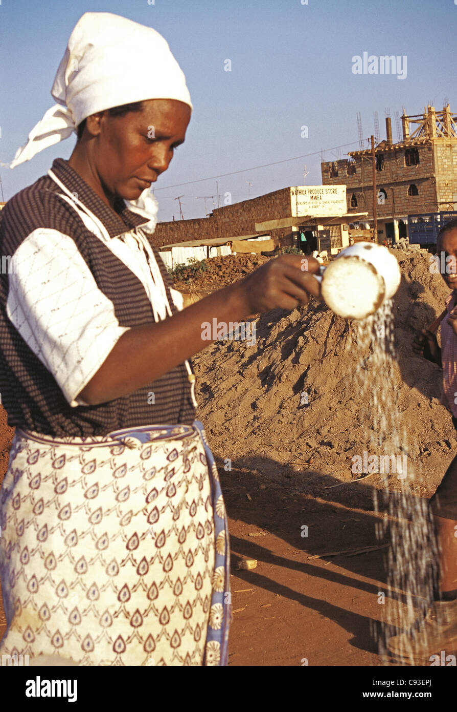 Meru Frau Reis gießen seine Qualität bei Duka mit Reis für Verkauf Meru Bezirk Markt Kenia zeigen Stockfoto