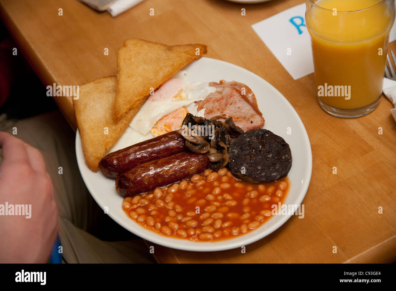 Ein "Greasy Spoon" gebraten englisches Frühstück - Speck, Ei, Würstchen, Bohnen, geröstetes Brot, Blutwurst - in einem Café UK Stockfoto