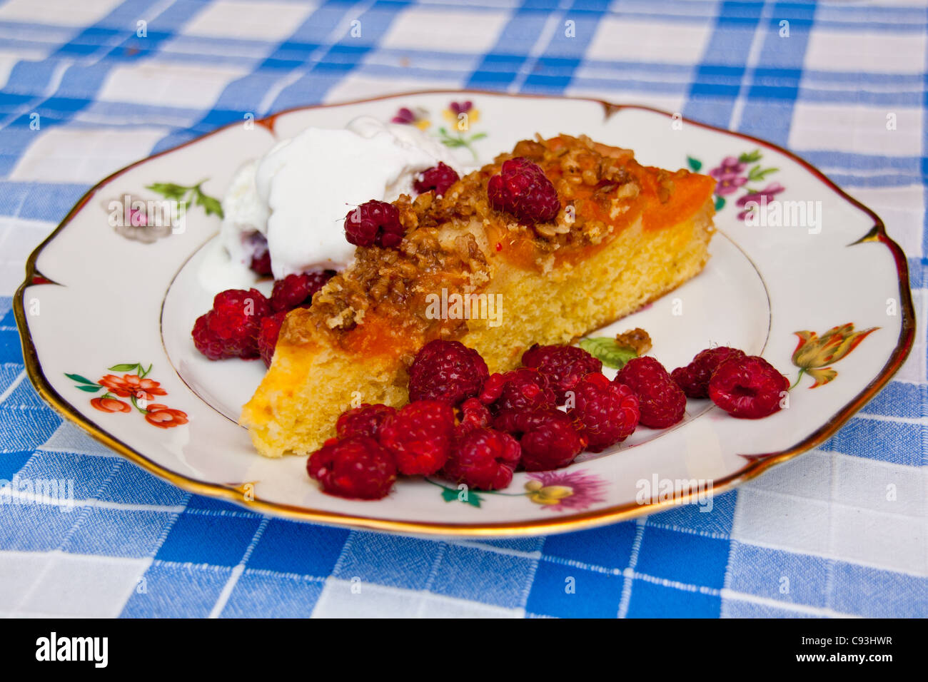 Aprikosen-Kuchen, mit Eis und Himbeeren auf einen dekorativen Teller serviert. Stockfoto