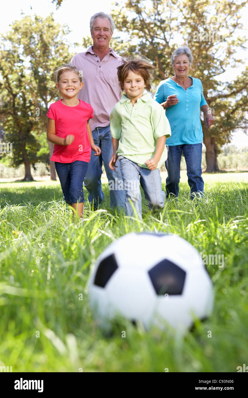 Großeltern spielen Fußball mit grandchilderen Stockfoto