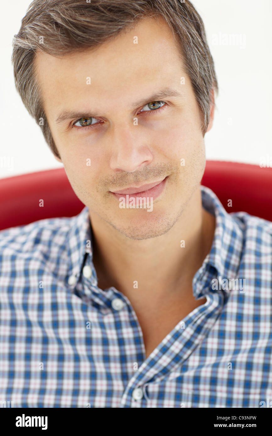 Mann sitzt im roten Stuhl Stockfoto