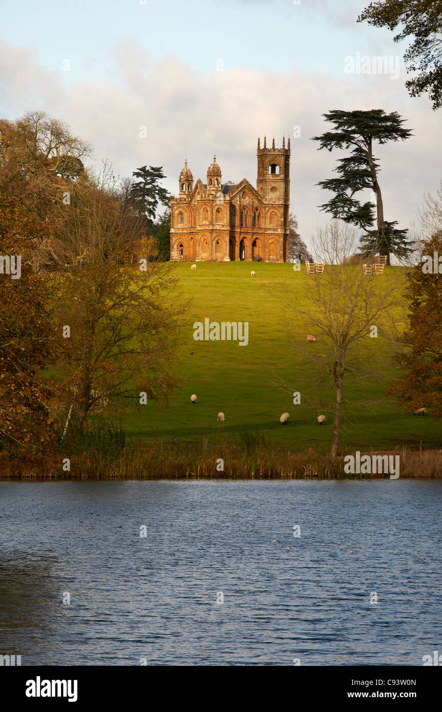 Grüne Felder führt zu historischen gotischen Tempel in den schönen Gärten der Stowe in North Buckinghamshire betrachtet über den See. Stockfoto