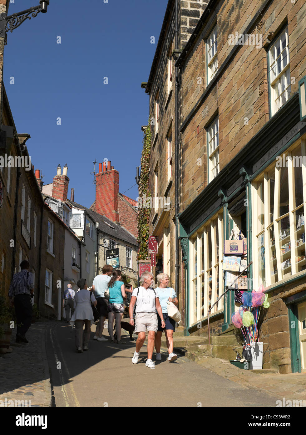 Menschen Touristen Besucher zu Fuß entlang der King Street im Sommer Robin Hoods Bay Village North Yorkshire England Vereinigtes Königreich Großbritannien und Nordirland GB Großbritannien Stockfoto