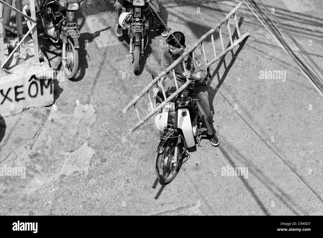 Asien, Vietnam, Ho-Chi-Minh-Stadt (Saigon). Asiatischer Mann den Transport eines Leddar mit dem Motorrad entlang Bui Vien St. in der Backpacker... Stockfoto