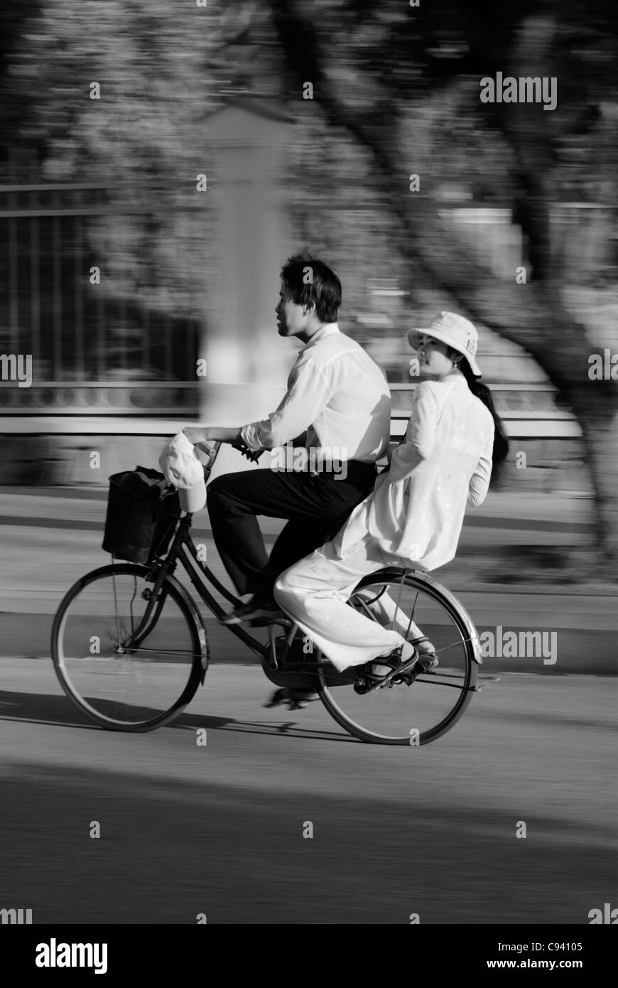 Asien, Vietnam, Hue. Jungen und Mädchen in traditionellen vietnamesischen weißen Kleid auf dem Fahrrad fahren. Stockfoto