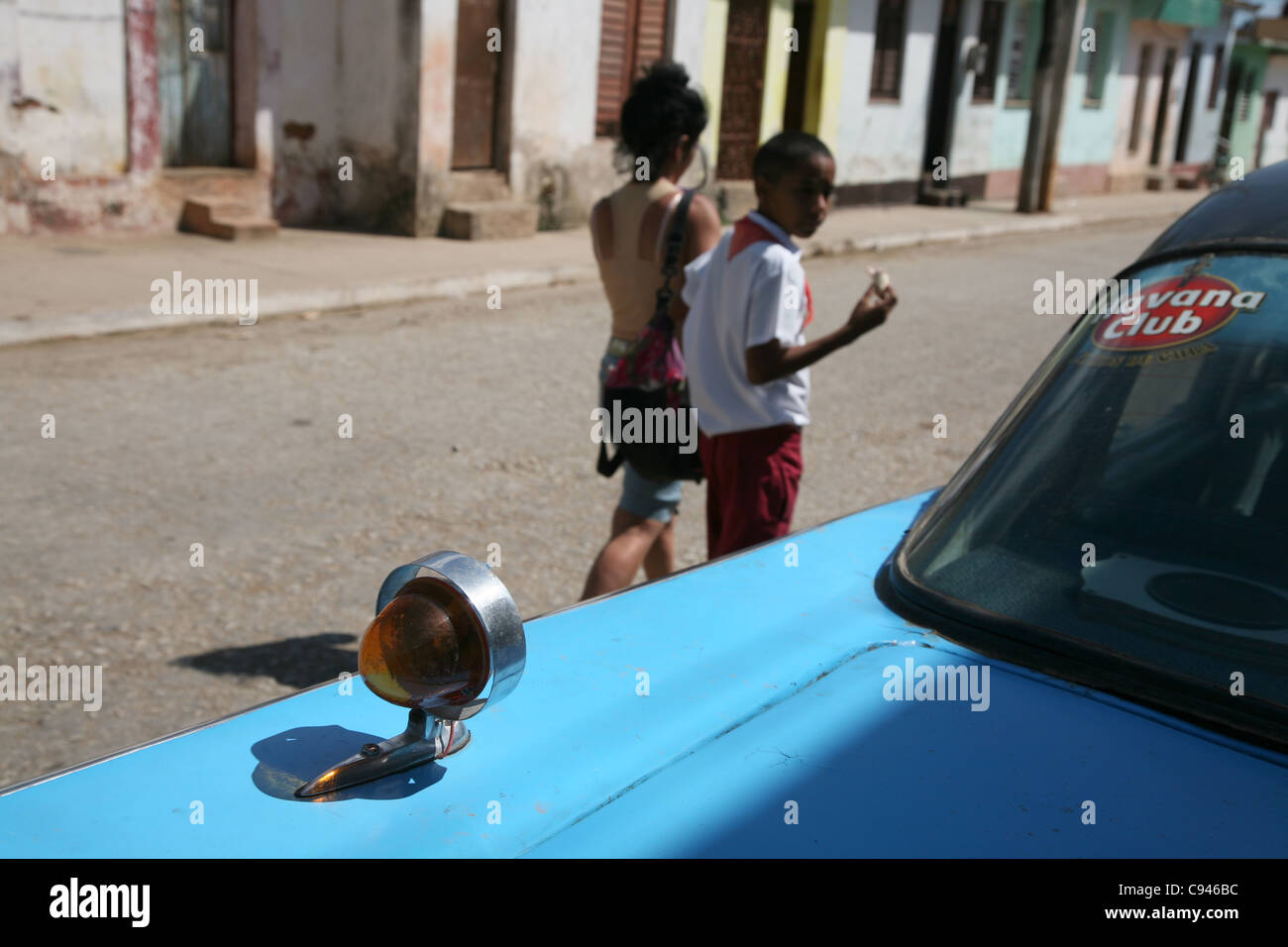 Kubanische Pionier vorbei US-Oldtimer mit Havana Club Rum Logo in Trinidad, Kuba. Stockfoto