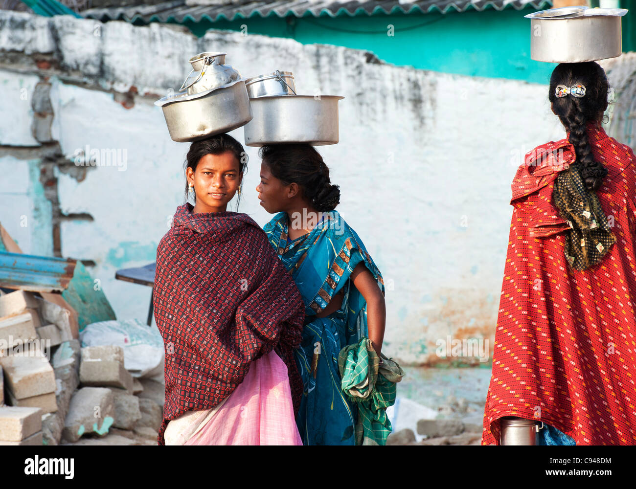 Drei niedrigere Kaste indischen Teenager Töpfe Reis auf ihren Köpfen tragen. Andhra Pradesh, Indien Stockfoto