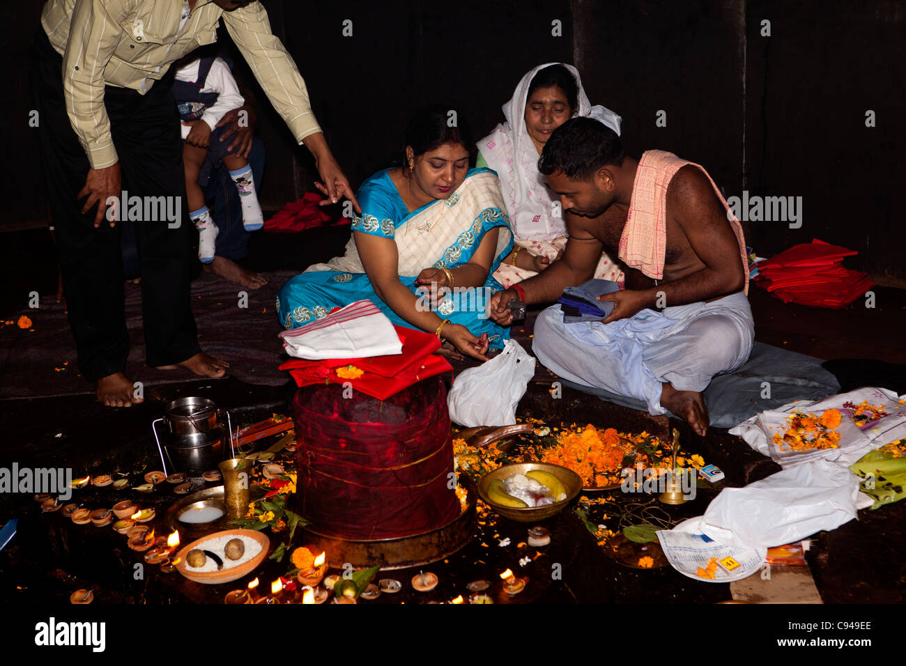 Indien, Assam, Guwahati, Navagraha Hill, Nabahraha Mandir, Gläubige und Hindu Priester am shivalingam Stockfoto