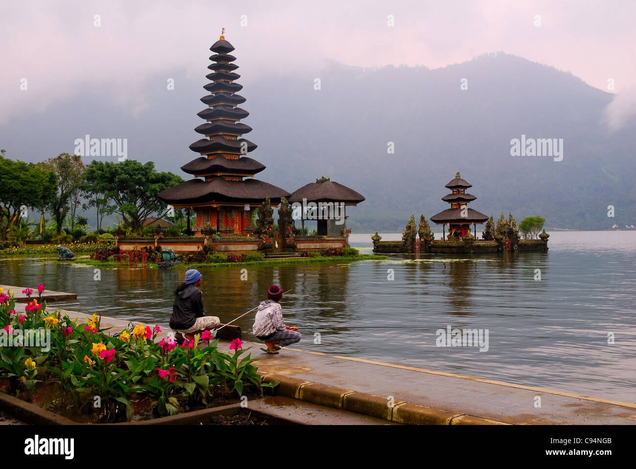 Zwei lokale Balinesen sind auf dem Tempelgelände Para Ulun Danu Angeln. Der See heißt Danau Bratan und liegt in Zentral-Bali Stockfoto