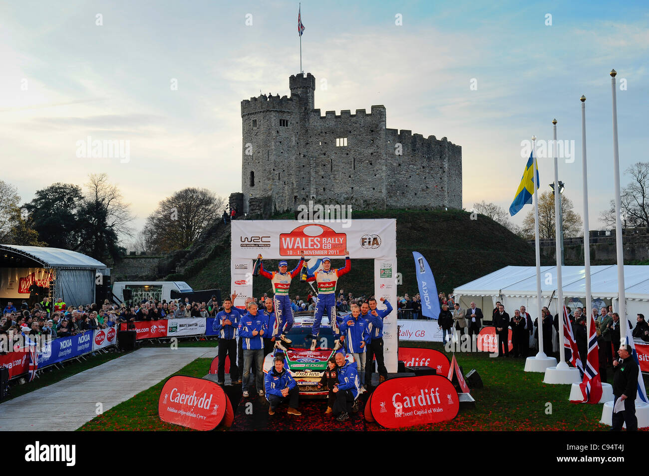 13.11.2011 Cardiff, Wales. Rallye-Sieger Jari-Matti Latvala (FIN) und Co-Pilot Mikka Anttila (FIN) in #4 Ford Abu Dhabi World Rally Team Ford Fiesta RS WRC Stand auf dem Podium mit ihrem Team unter anderem Chef Malcolm Wilson und seinem Teamkollegen Mikko Hirvonen (FIN) an das zeremonielle Finish im Boden Stockfoto