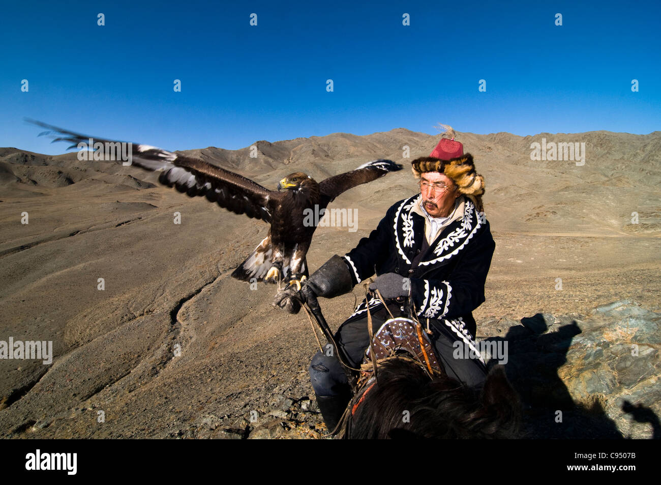 Kasachische eagle Hunter und seinem Steinadler in der Altai-Region von Bayan-Ölgii in der westlichen Mongolei. Stockfoto