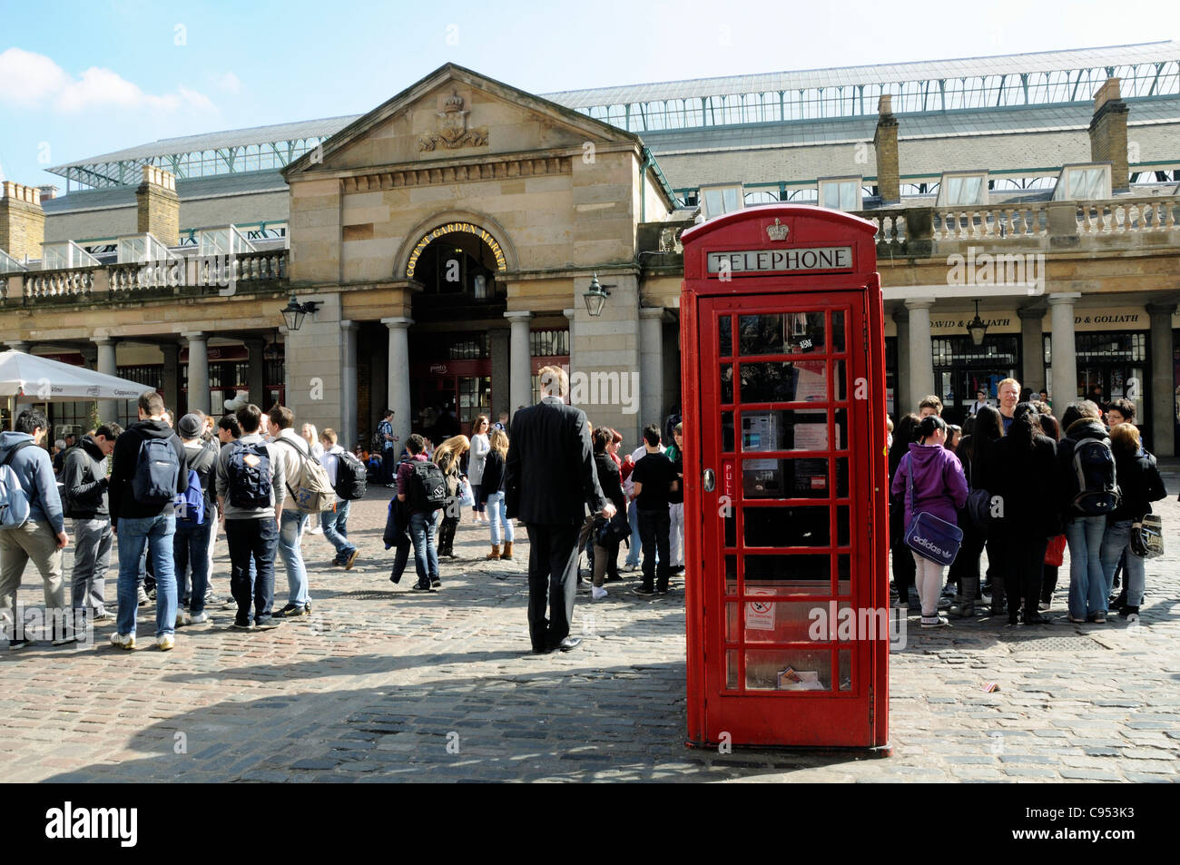 Covent Garden Market mit roten Telefonzelle im Vordergrund und Menschen hinter London England UK Stockfoto