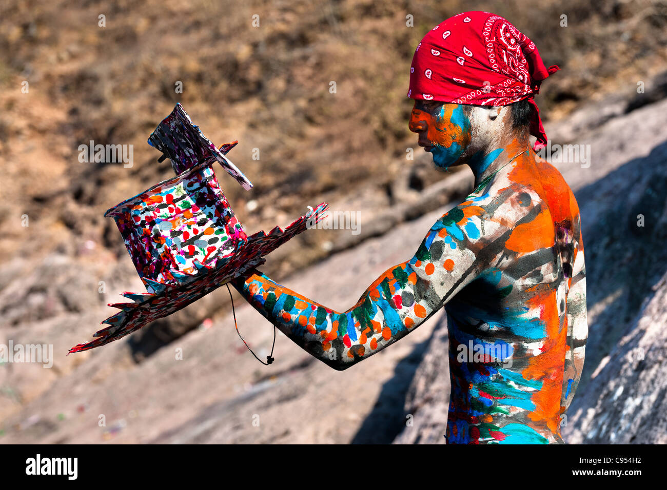 Ein Indianerjunge Cora malt seinen bunten Hut vor der religiösen rituellen Zeremonie der Karwoche in Jesús María, Mexiko. Stockfoto