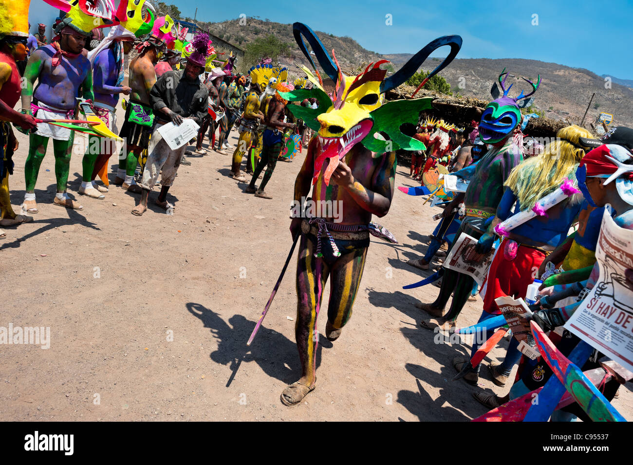 Ein Cora indischen Mann mit einem bunten Dämon Maske, Wanderungen während der heiligen Zeremonie der Heiligen Woche in Jesús María, Nayarit, Mexiko. Stockfoto