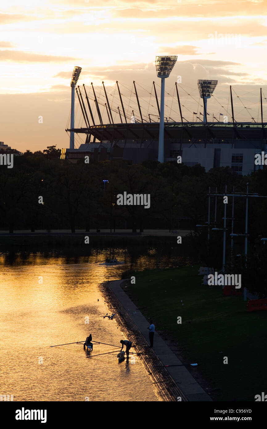 Ruderer nehmen den Yarra River mit dem Melbourne Cricket Ground im Hintergrund. Melbourne, Victoria, Australien Stockfoto