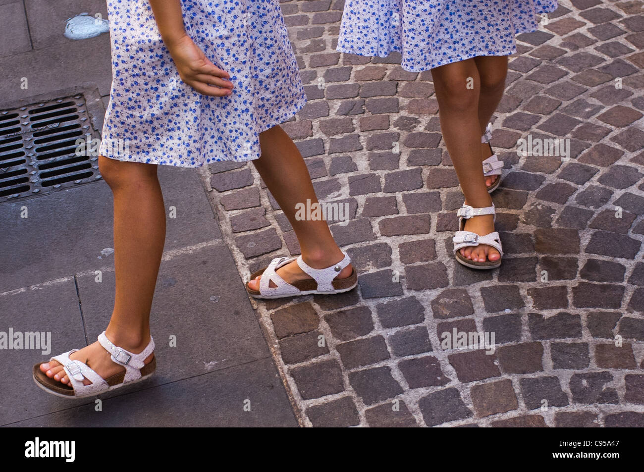 Zwei Schwestern mit identischen Kleider und Sandalen. Stockfoto