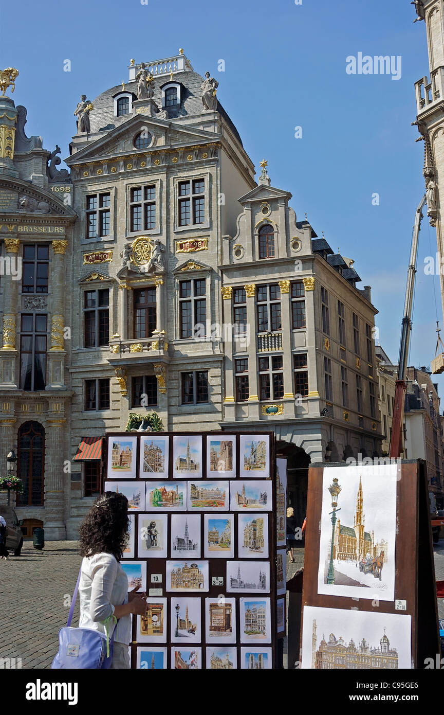 Eine Frau schaut Bilder der belgischen Seiten bei einem Spaziergang durch Brüssel Grand Place. Brüssel, Belgien Stockfoto